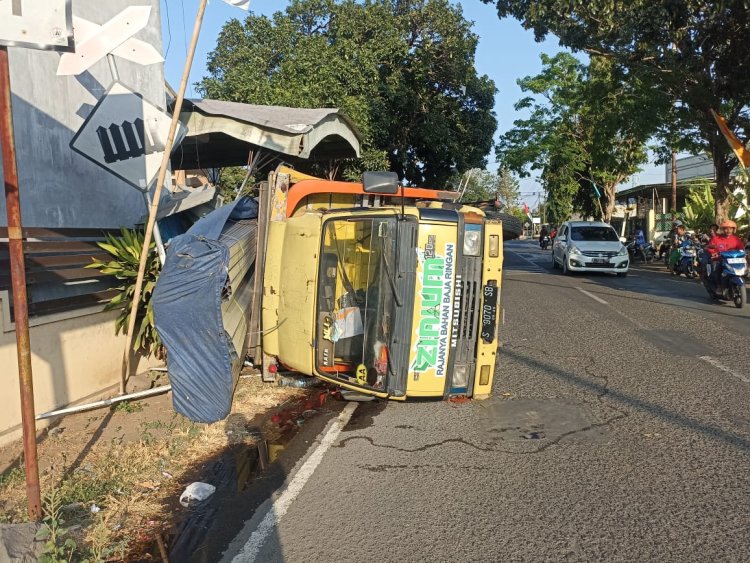 Truk Angkut Baja Terguling Timpa Pagar Rumah Warga